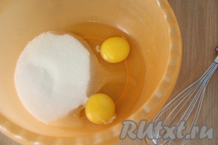 В глубокую миску всыпать сахар и добавить яйца. С помощью венчика взбить яйца с сахаром до однородности.